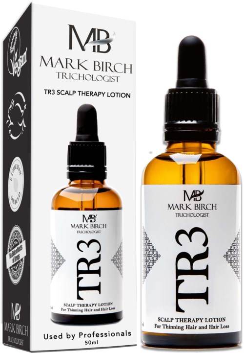 A small amber glass bottle with a dropper cap and label, next to a box, for scalp therapy lotion, used by professionals.