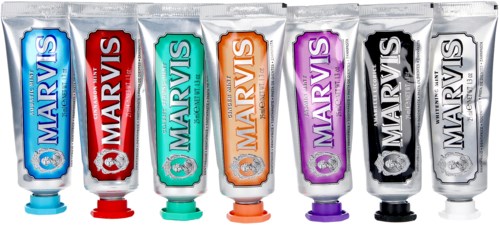 Six tubes of toothpaste in different colors and flavors, arranged in a row.