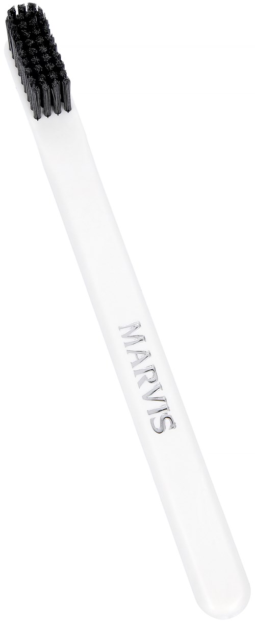 A toothbrush with a white handle and black bristles. The handle has the word "MARVIS" written on it.