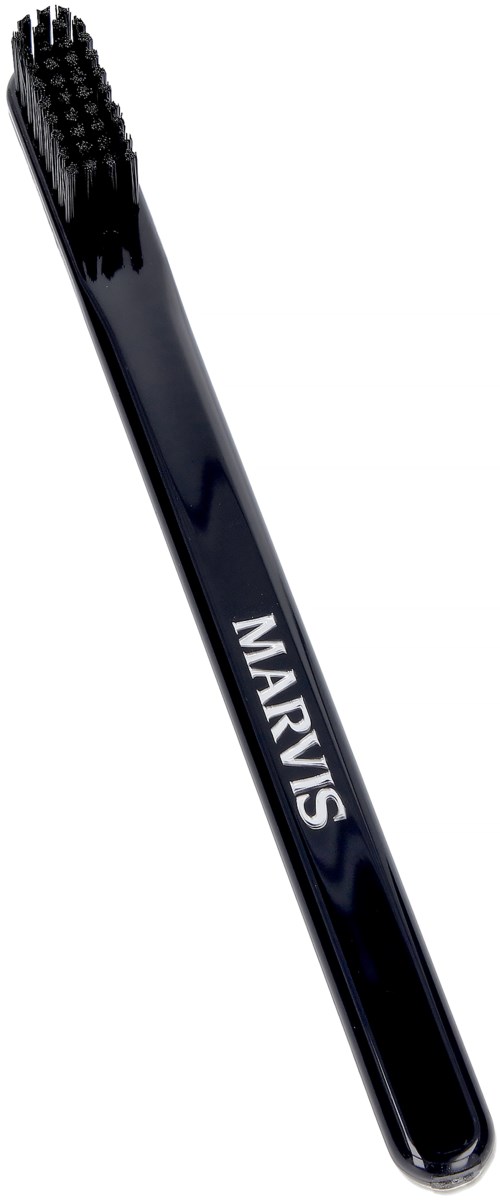 A black eyebrow brush with dense bristles and the brand name "MARVIS" on the handle.