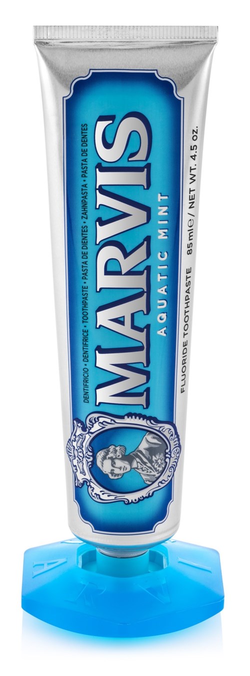 A tube of Marvis toothpaste with a blue and white design, placed on a blue stand.