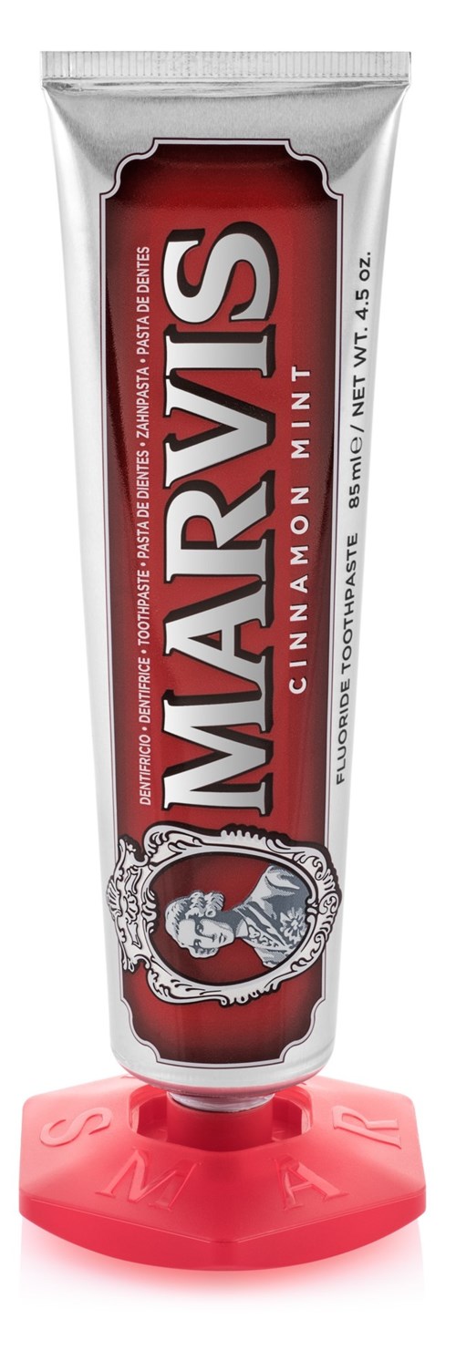 A tube of MARY'S cinnamon mint lip balm with a pink cap, standing upright.
