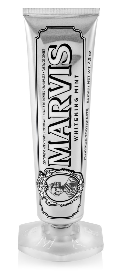 A peppermint-flavored whitening toothpaste in a silver tube with black and white label, standing on a plastic cap.