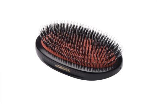 A hairbrush with black and red bristles, oval shape, used for brushing hair.
