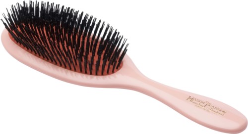A pink hairbrush with black bristles laid on a white background.