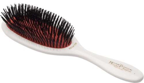 A white hairbrush with black and red bristles, designed for detangling hair, resting on a plain white surface.