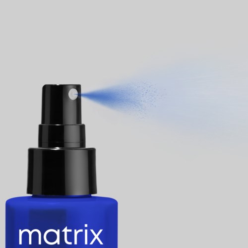 Eine blaue Sprühflasche mit schwarzem Deckel, die einen feinen Nebel nach vorne sprüht.
