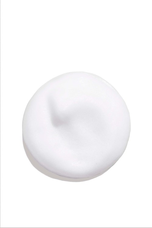 Ein Klecks weißen Cremes oder Lotion auf weißem Hintergrund. Es sieht glatt und weich aus.