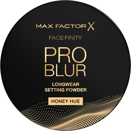 Pyöreä musta etiketti Max Factor kasvojen kiinnityspuuderiä varten, hunajan sävy, kultaisella tekstillä ja pistekuviolla.