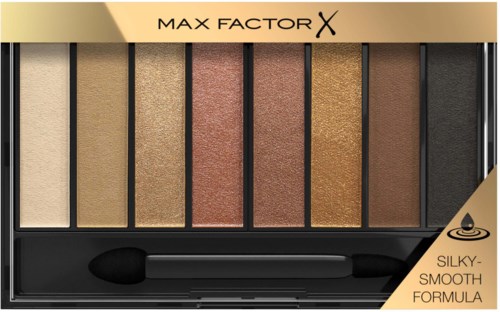 Eine Make-up-Palette mit sieben Farbtönen von hell bis dunkel, beschriftet 'Max Factor X' und 'Silky-Smooth Formula' an den Ecken.