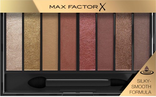 Een oogschaduwpalette met verschillende tinten goud en roze, in rechthoekige bakjes. Inclusief een zwarte applicator.