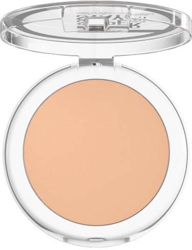En kompakt med beige puder och ett genomskinnligt, runt lock öppet, som visar en ljus makeup-produkt.