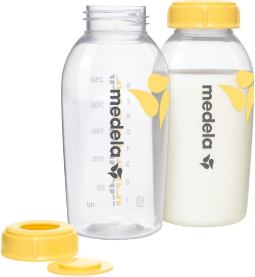 Zwei Babymilchflaschen, eine durchsichtig und die andere mit Milch gefüllt, beide mit 'medela' bedruckt, gelbe Deckel und Blattmuster.