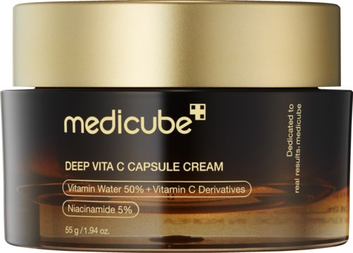 Een zwarte pot met gouden deksel, gemerkt 'medicube' en 'Deep Vita C Capsule Cream.' Bevat vitaminewater en niacinamide.