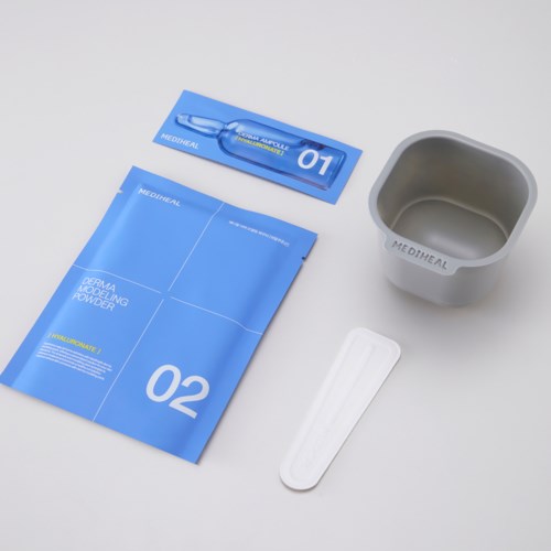 Medical skincare product set includes a blue packet, a small cup, a spatula, and a tube.