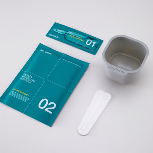 A skincare kit with a tube, a bag, a bowl, and a spatula on a white background.