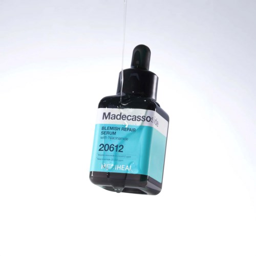 Een klein zwarte fles met pipetdop, getiteld "Madecassoside" voor huidverzorging, hangt in de lucht.