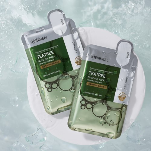 Two teabag-shaped facial masks with bubbles inside are shown on a white plate in water.