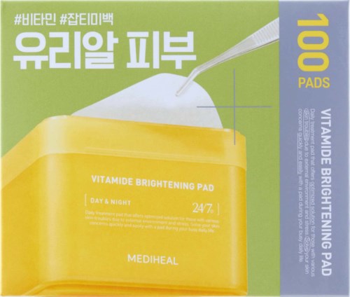Groene en gele doos met tekst over vitamine-verhelderende pads en een kleine lepel erop.