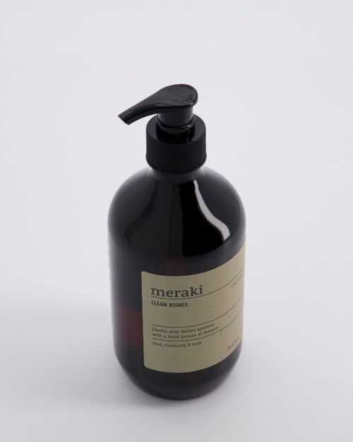 En svart plastflaska med pump och en beige etikett som nämner 'meraki' och 'dream dims'.