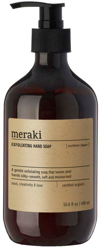A dark bottle with a pump, labeled 'meraki' and 'exfoliating hand soap,' is used for washing hands gently.