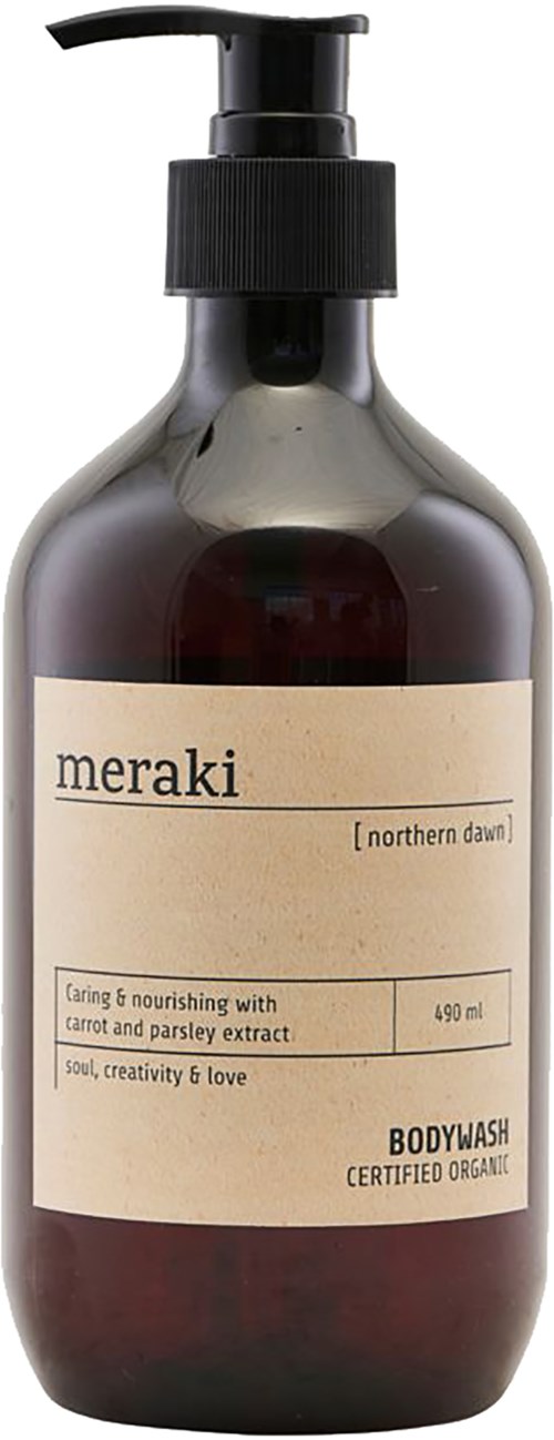 A dark bottle with a pump, labeled 'meraki' and 'northern dawn,' contains organic body wash with carrot and parsley extract.
