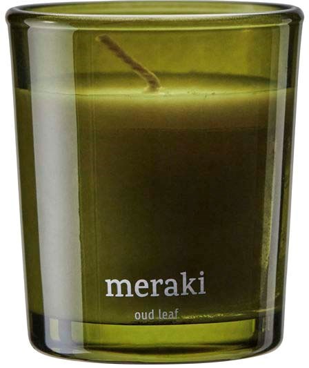 A green candle holder with the words "meraki" and "oud leaf" on it.