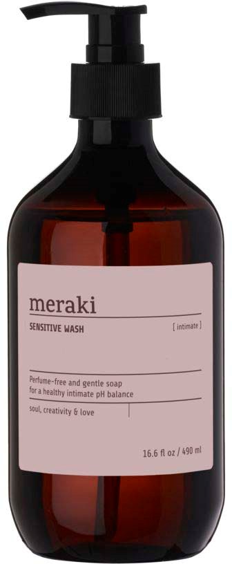A dark amber soap bottle with a pump, label reads 'meraki Sensitive Wash' for intimate skin, 16.6 oz.