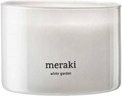 A white candle jar with black text reading "meraki" and "white garden."