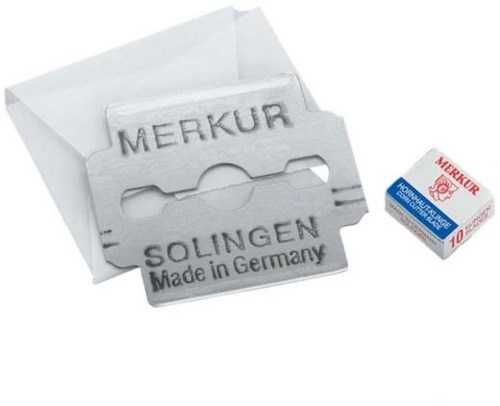 A straight razor blade with text, a white paper envelope, and a small box labeled 'Merkur'.