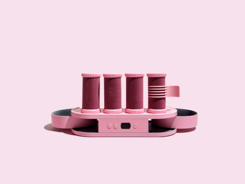A pink device with four vertical rollers and a control panel, meant for grooming or beauty purposes.
