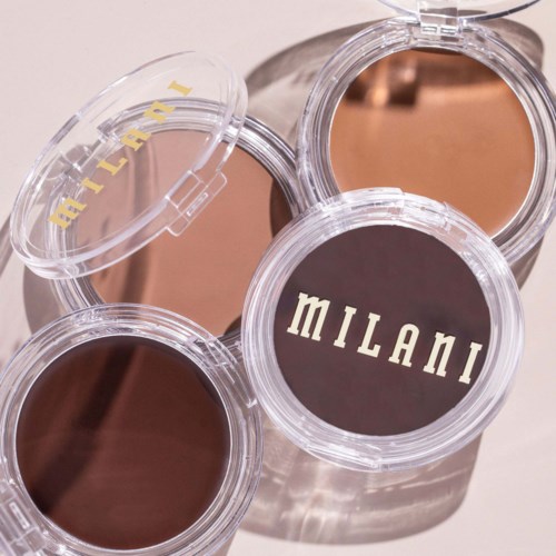 Three containers of Milani makeup products with one open, revealing the powder inside.