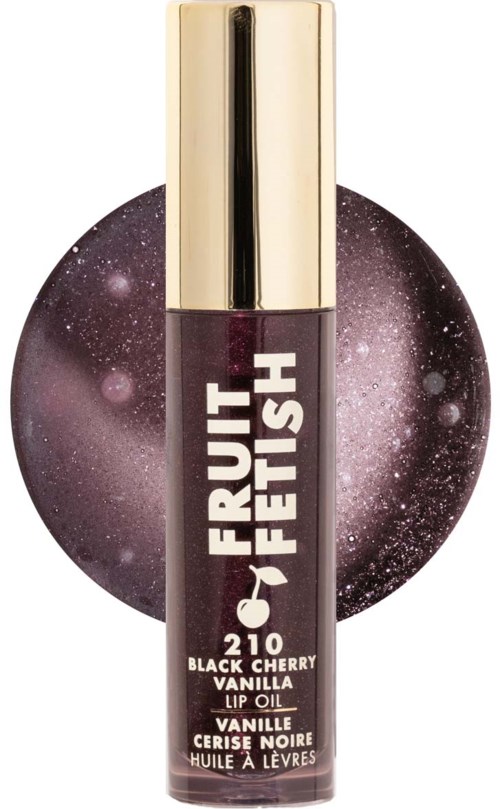 Lip oil in a clear tube with gold cap, labeled "Fruit Fetish Black Cherry Vanilla." Dark purple packaging with a starry background.