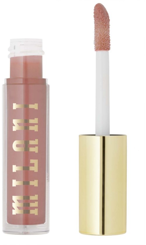 Ett läppglans med genomskinlig behållare, rosa gloss inuti, och en vit och guldaktig topp. Applikatorn är synlig.