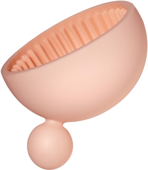 Een lichtroze moddermasker-applicator met een getextureerde binnenkant en een ronde handvat.