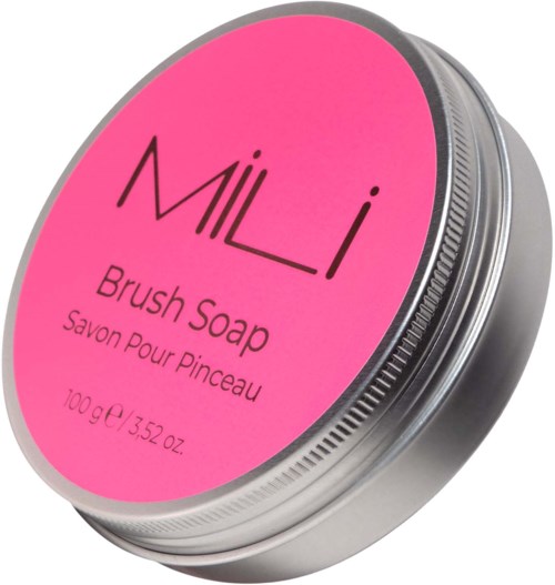 Een ronde metalen container met een roze label met 'MILI Brush Soap' en gewichtinformatie.