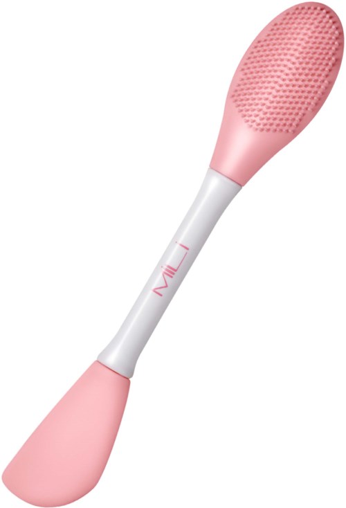 A pink and white silicone facial cleansing brush with a textured oval head and a curved handle.