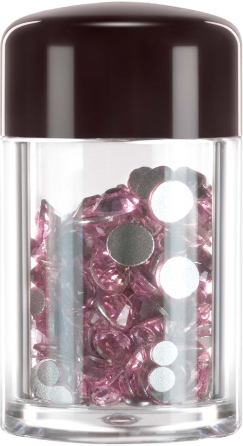 A container filled with pink and transparent round beads and white spots on the glass.