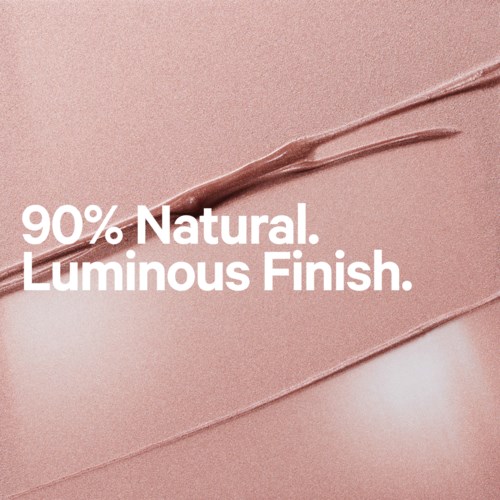 Texten säger: 90% Naturlig. Lyst Finish. på en rosa bakgrund.
