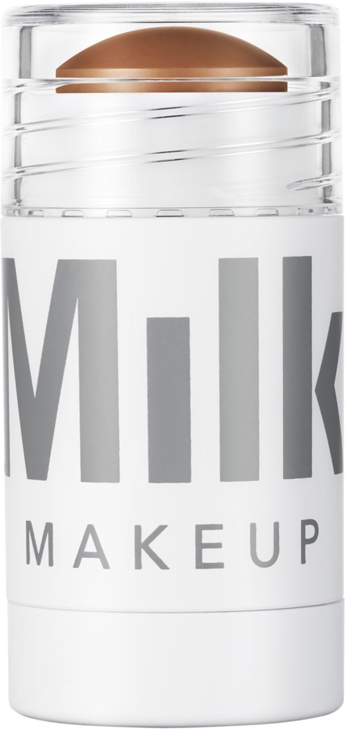 Ein Behälter mit der Bezeichnung 'Milk Makeup' und einem metallisch braunen kugelartigen Objekt oben.