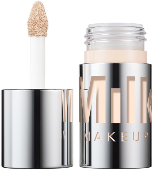 A beige lip gloss applicator and a clear container with beige makeup stick inside, labeled 'MILK MAKEUP' in shiny silver.