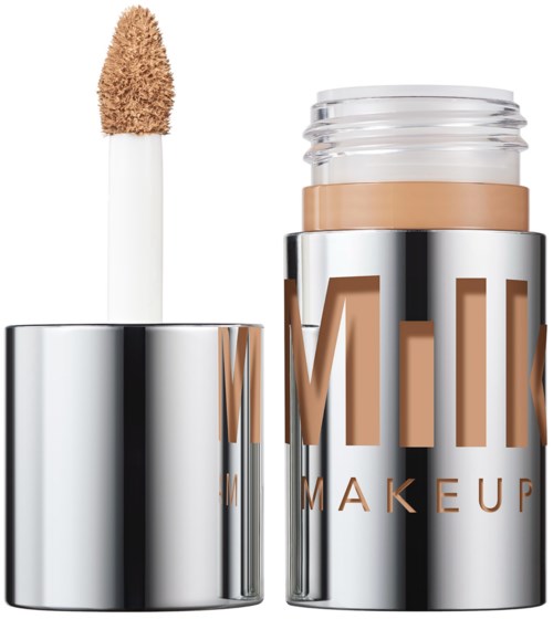 Een vloeibare correctievloeistof met sponsapplicator in een zilveren tube gemerkt 'MINI MAKEUP.'