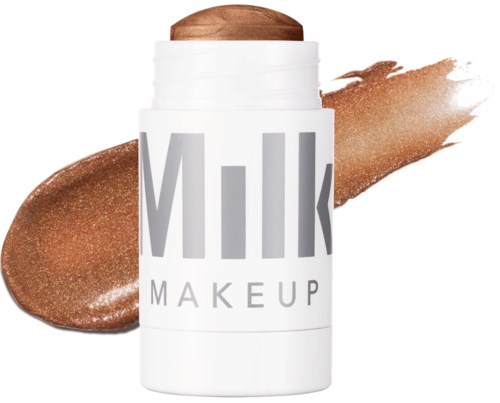 Valkoinen purkki merkinnällä "Milk Makeup" ja sisällä ruskea meikkipuna, taustalla pronssinvärinen meikkiväri.