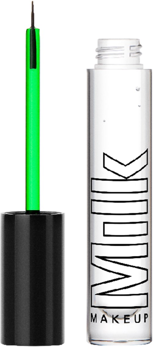 Een heldere fles met zwarte tekst en een witte vloeistof binnen, en een make-upkwast met zwarte handvat en groen licht.