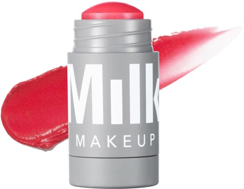A milk makeup product in a gray container with pinkish lipstick and red and pink swipes behind.