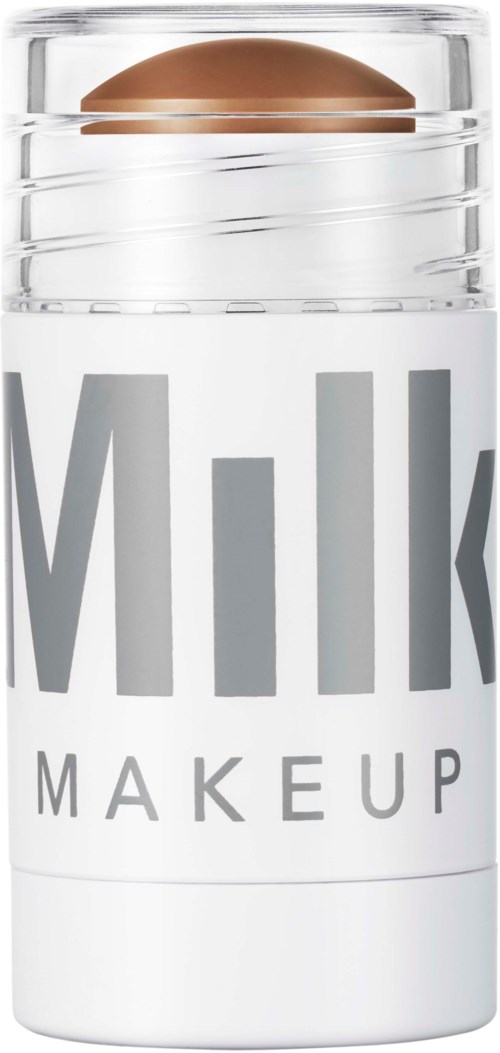 Ett hudvårdsprodukt i en tydlig behållare, märkt "Milk Makeup," med en brunsjuk tablett inuti.