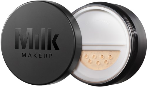 Een ronde container met een zwart deksel gemarkeerd "Milk Makeup" en een beige spons binnenin.