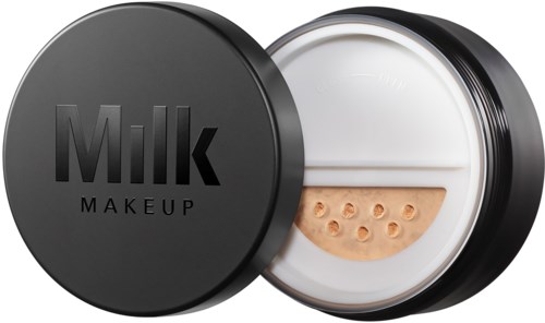 Ein schwarzer runder Behälter mit Deckel, auf dem 'Milk Makeup' steht. Drinnen ist eine beige Creme mit Löchern sichtbar.