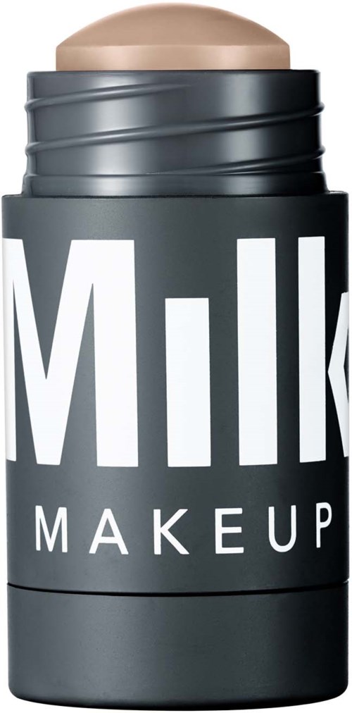Een zwarte make-up stick verpakking met witte tekst die 'Milk Makeup' zegt en een beige product zichtbaar bovenaan.