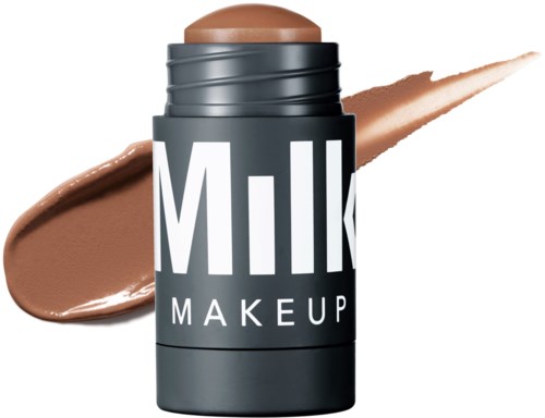 Eine Tube Foundation in Beige, mit "Milk Makeup" beschriftet, mit Makeup auf weißem Hintergrund.